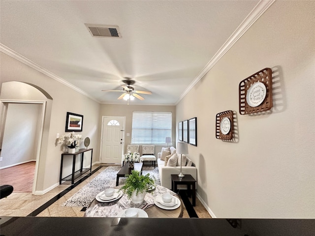 living room with ceiling fan and ornamental molding