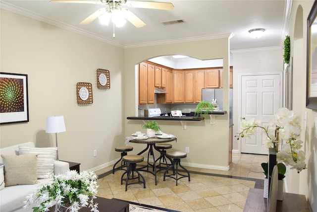 kitchen with a breakfast bar area, kitchen peninsula, crown molding, and ceiling fan