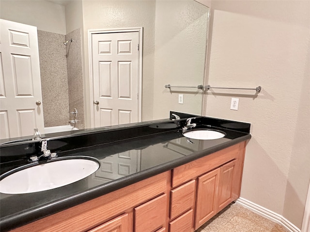 bathroom featuring vanity and tiled shower / bath