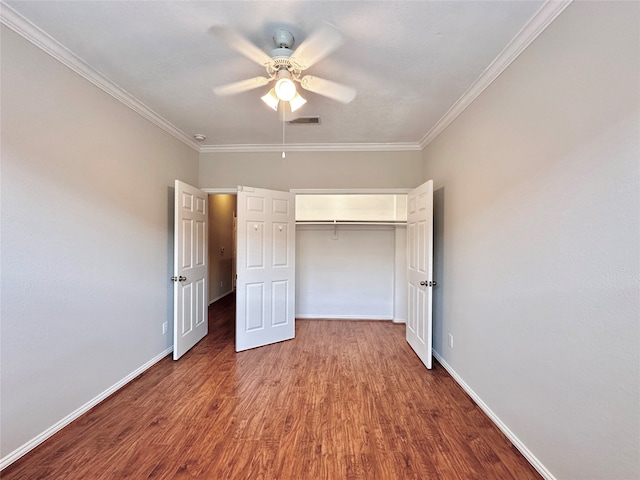 unfurnished bedroom with ceiling fan, a closet, dark hardwood / wood-style floors, and ornamental molding