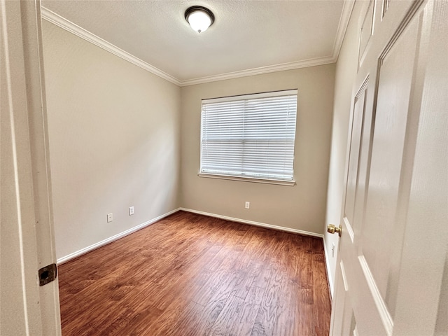 empty room with crown molding and hardwood / wood-style floors