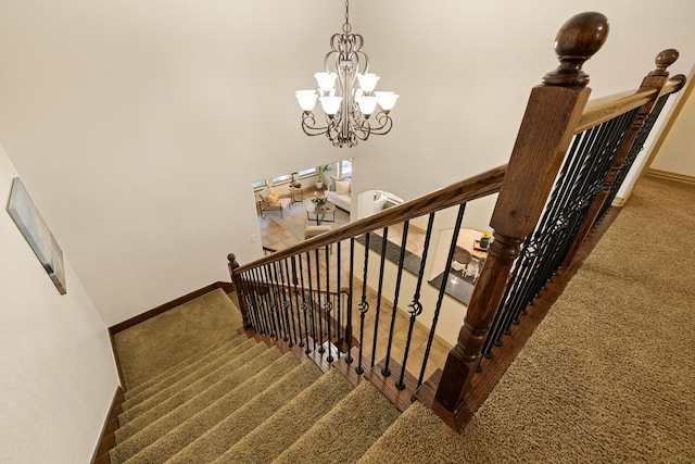 stairs featuring carpet flooring, a towering ceiling, and an inviting chandelier