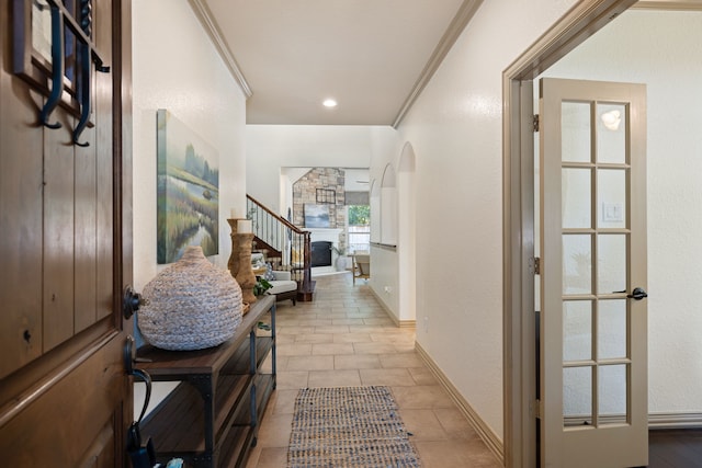 hallway with light tile patterned flooring and crown molding