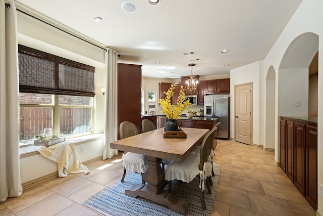 dining space featuring light tile patterned floors and an inviting chandelier