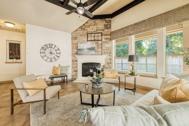 tiled living room with vaulted ceiling with beams, ceiling fan, and a stone fireplace