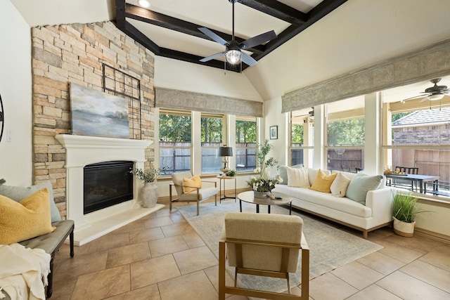 sunroom / solarium featuring lofted ceiling with beams, a stone fireplace, and ceiling fan