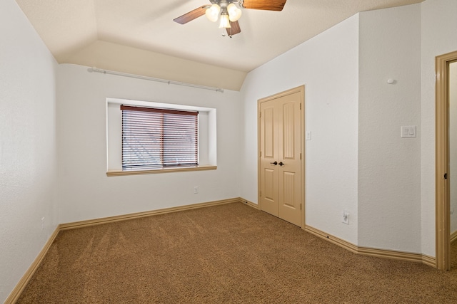 carpeted spare room featuring ceiling fan and lofted ceiling