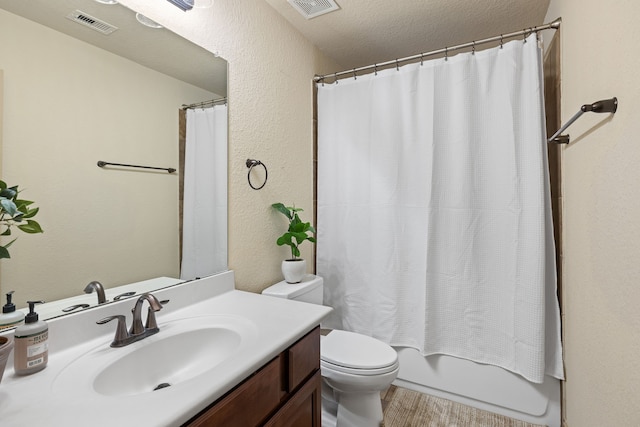 full bathroom with hardwood / wood-style floors, vanity, toilet, a textured ceiling, and shower / tub combo