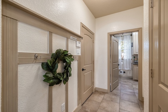 interior space with a textured ceiling and light tile patterned flooring