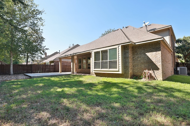 back of house featuring a lawn, cooling unit, and a patio