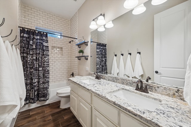 full bathroom featuring hardwood / wood-style floors, vanity, toilet, and shower / tub combo with curtain