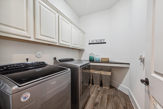 laundry room with washing machine and dryer, cabinets, and dark hardwood / wood-style floors