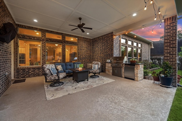 view of patio with area for grilling, an outdoor living space with a fire pit, and exterior kitchen