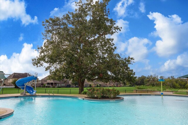 view of swimming pool with a water slide