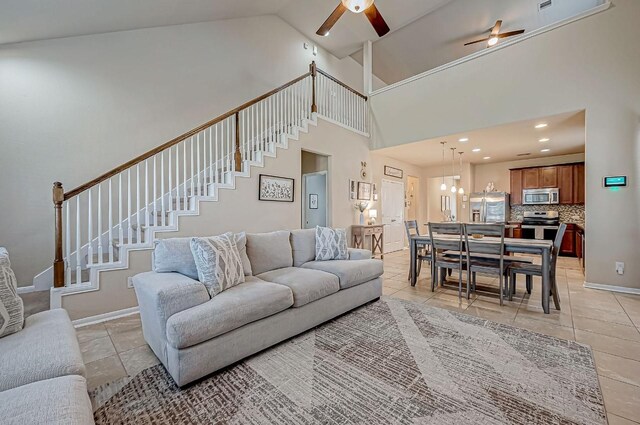 living room featuring light tile patterned floors, high vaulted ceiling, and ceiling fan