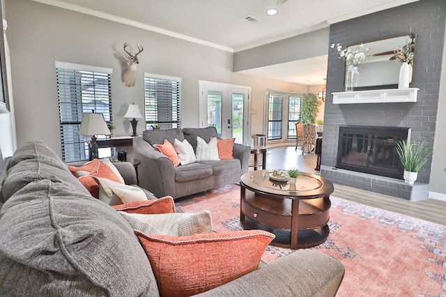 living room featuring crown molding, a fireplace, and light wood-type flooring