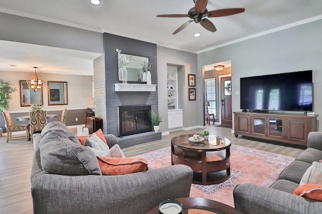 living room with built in shelves, a fireplace, and light wood-type flooring