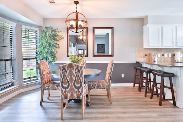 dining room with light wood-type flooring and a chandelier