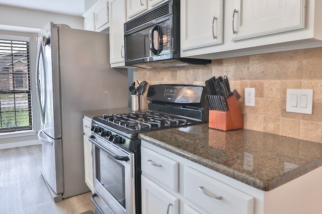 kitchen with stainless steel gas stove, a healthy amount of sunlight, and white cabinetry