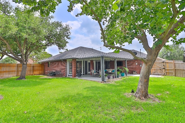 rear view of house with a yard and a patio area