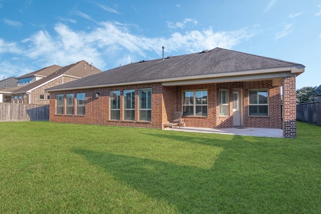 back of property with a lawn and a patio area