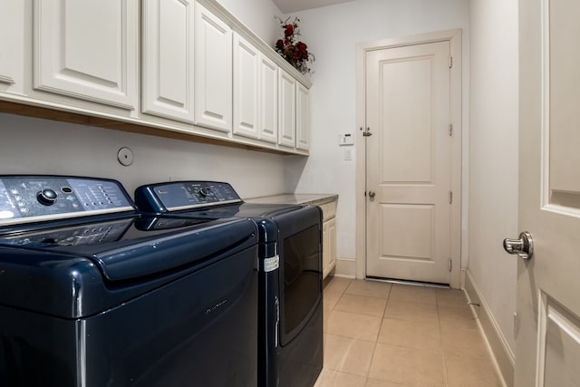 laundry area featuring cabinets, independent washer and dryer, and light tile patterned floors