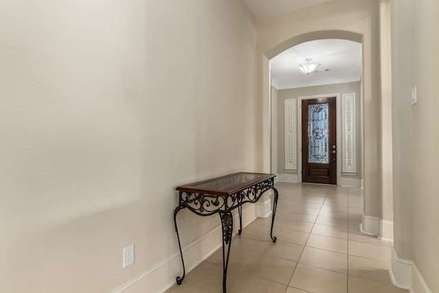 foyer entrance featuring crown molding and light tile patterned flooring