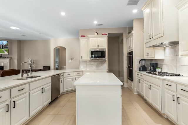 kitchen featuring a kitchen island, sink, stainless steel appliances, and tasteful backsplash