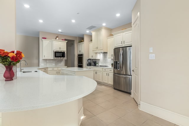 kitchen featuring kitchen peninsula, appliances with stainless steel finishes, white cabinets, and sink