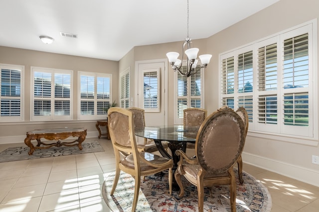 tiled dining area featuring a chandelier