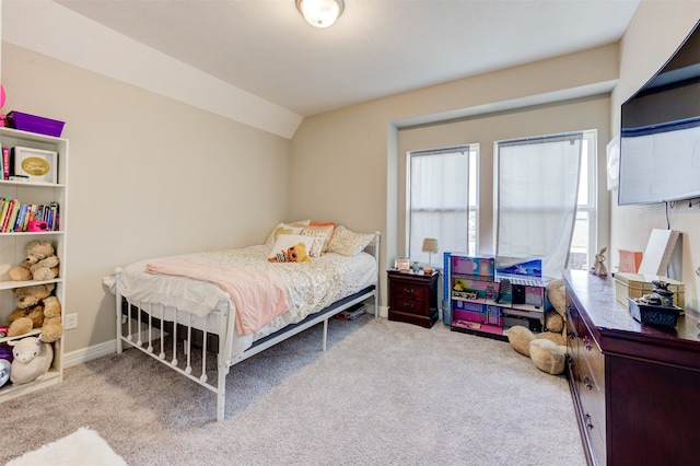 bedroom featuring light colored carpet and vaulted ceiling