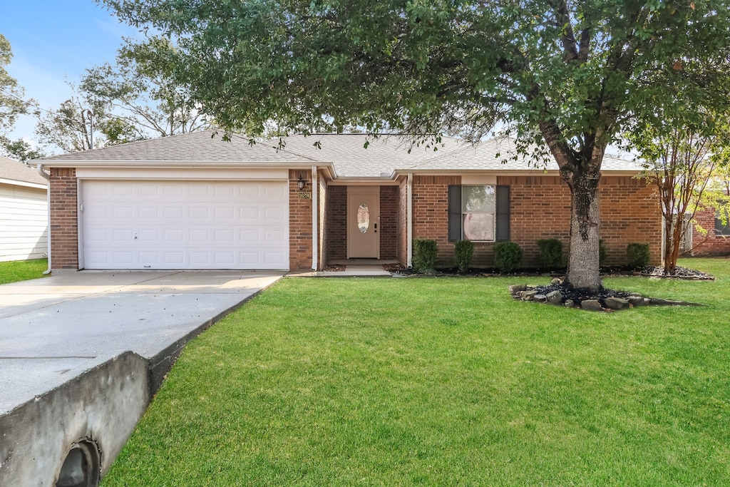 ranch-style home with a front yard and a garage