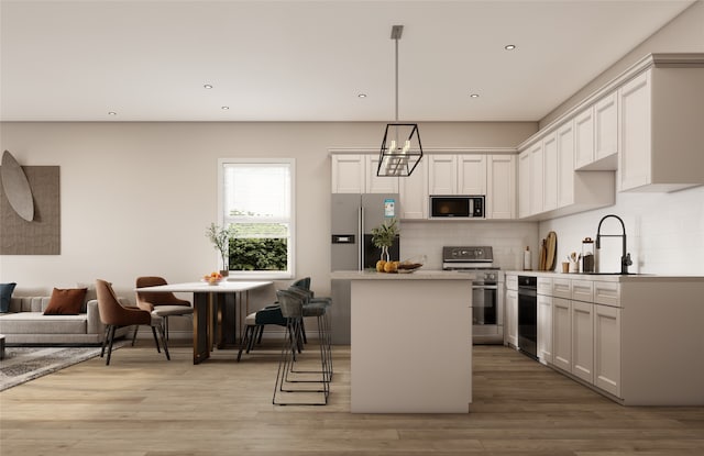 kitchen with stainless steel appliances, sink, pendant lighting, light hardwood / wood-style flooring, and a kitchen island