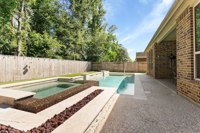 view of swimming pool with an in ground hot tub and a patio