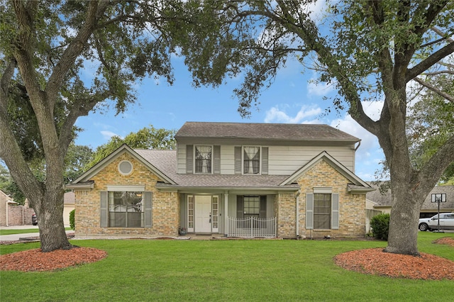 view of property featuring covered porch and a front yard