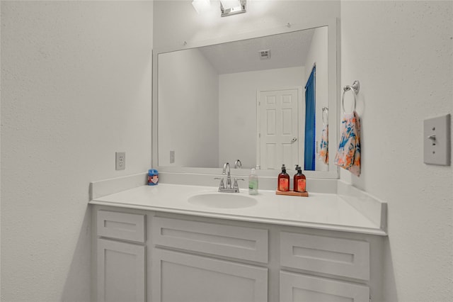 bathroom with vanity and a textured ceiling