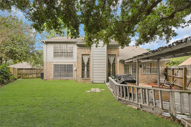 back of house featuring central air condition unit, a wooden deck, and a lawn