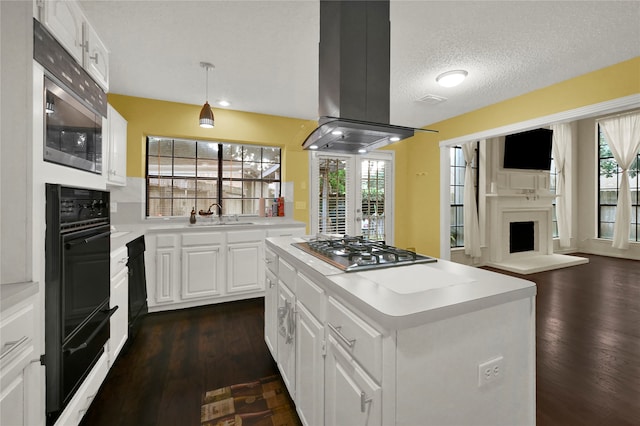 kitchen featuring a center island, white cabinets, island range hood, dark hardwood / wood-style flooring, and stainless steel appliances