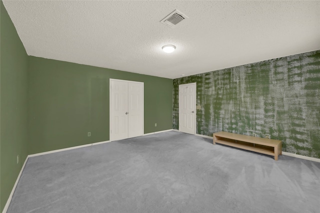 carpeted spare room with a textured ceiling