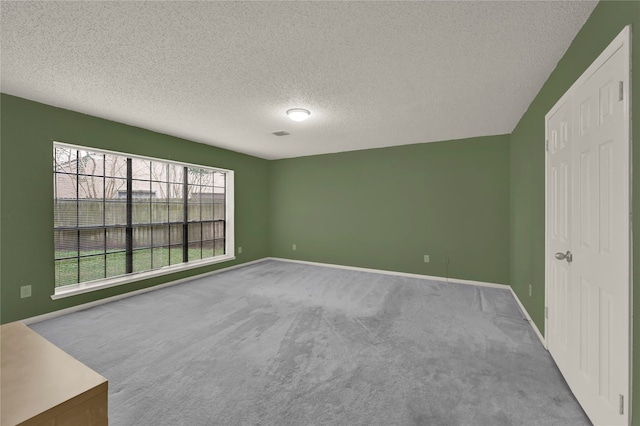 carpeted spare room with a textured ceiling