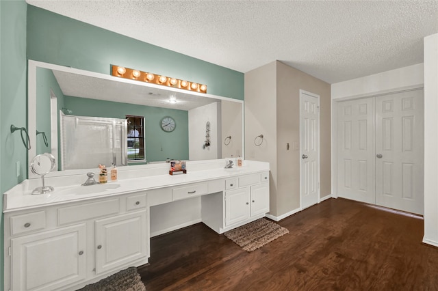 bathroom featuring walk in shower, vanity, a textured ceiling, and hardwood / wood-style flooring