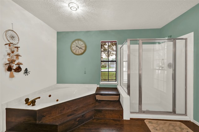 bathroom featuring plus walk in shower, a textured ceiling, and hardwood / wood-style flooring