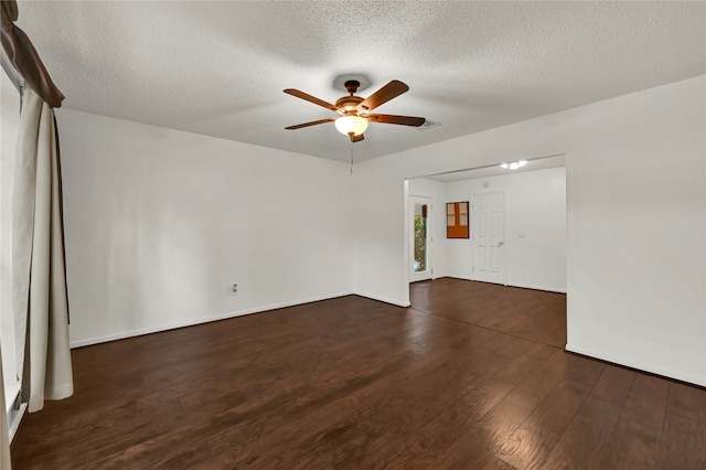 empty room with ceiling fan, dark wood-type flooring, and a textured ceiling