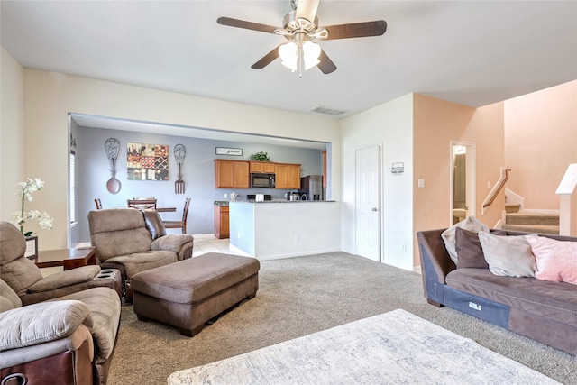 carpeted living room with ceiling fan