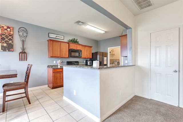 kitchen featuring kitchen peninsula, stone countertops, light colored carpet, and black appliances