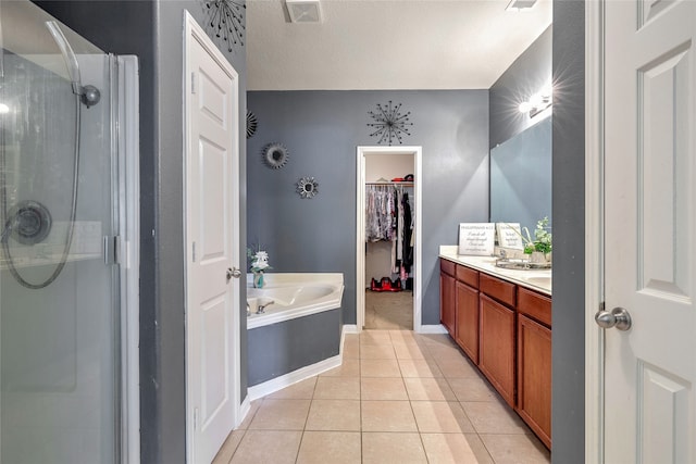 bathroom with tile patterned floors, vanity, separate shower and tub, and a textured ceiling