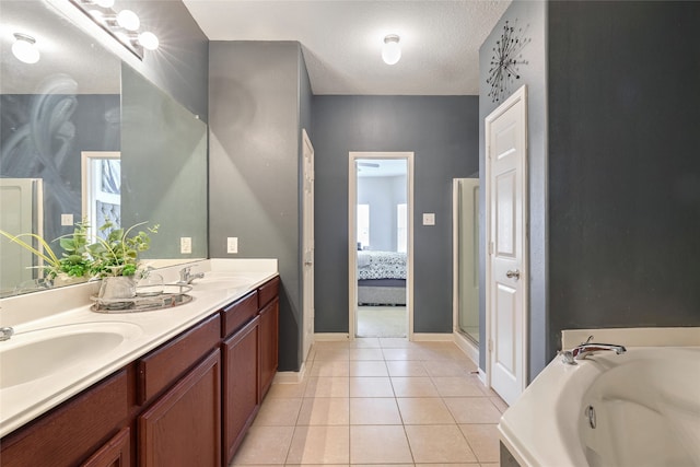 bathroom featuring tile patterned floors, vanity, a textured ceiling, and plus walk in shower