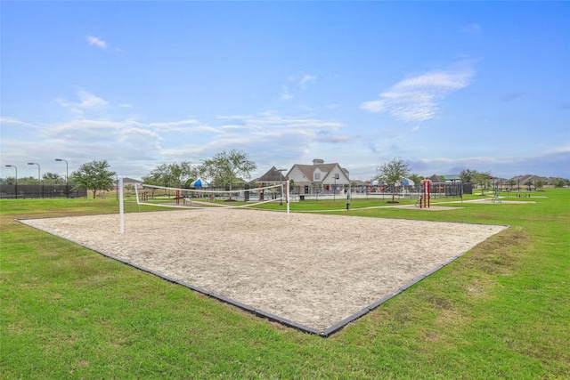 surrounding community with volleyball court and a lawn