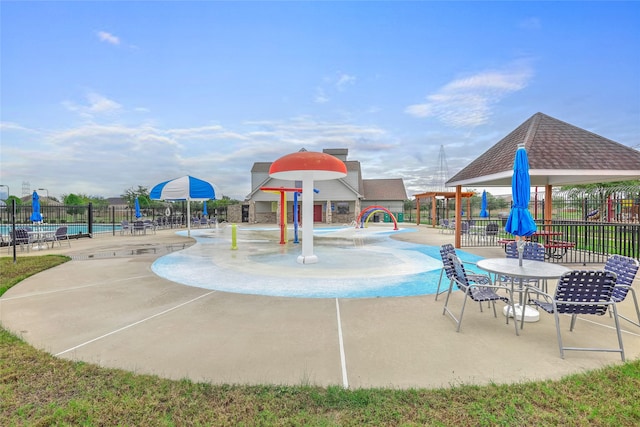 view of playground featuring pool water feature, a patio, and a community pool