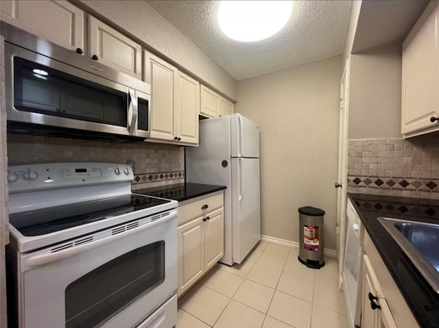 kitchen featuring backsplash, a textured ceiling, white appliances, sink, and light tile patterned floors